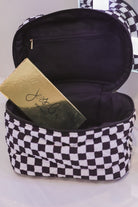 a structured bag with a spacious interior, a secure double zip around closure, a top handle, and gold accents on a quilted body in checkerboard checkered (black/white)