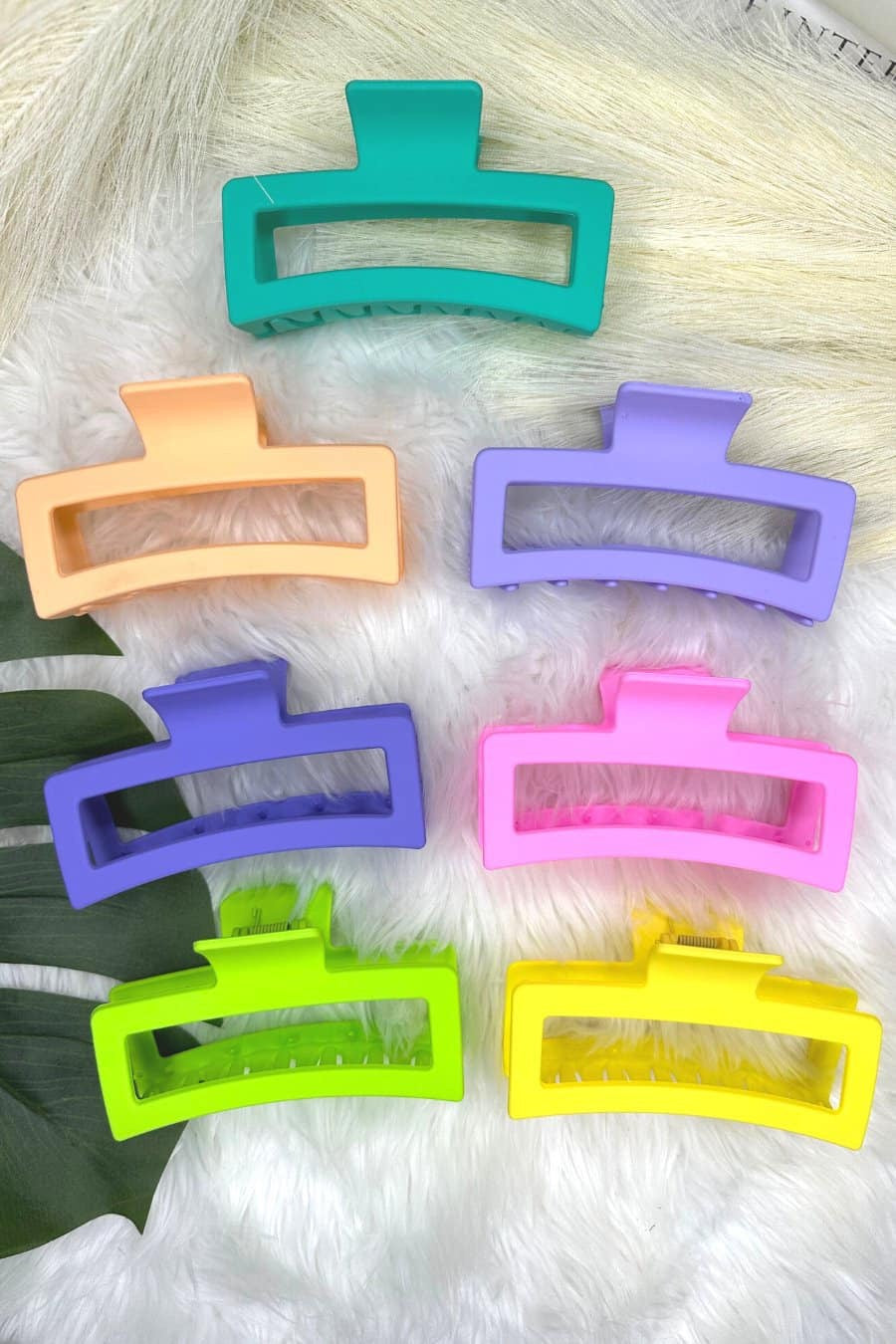 Set of colorful hair clips on a textured surface