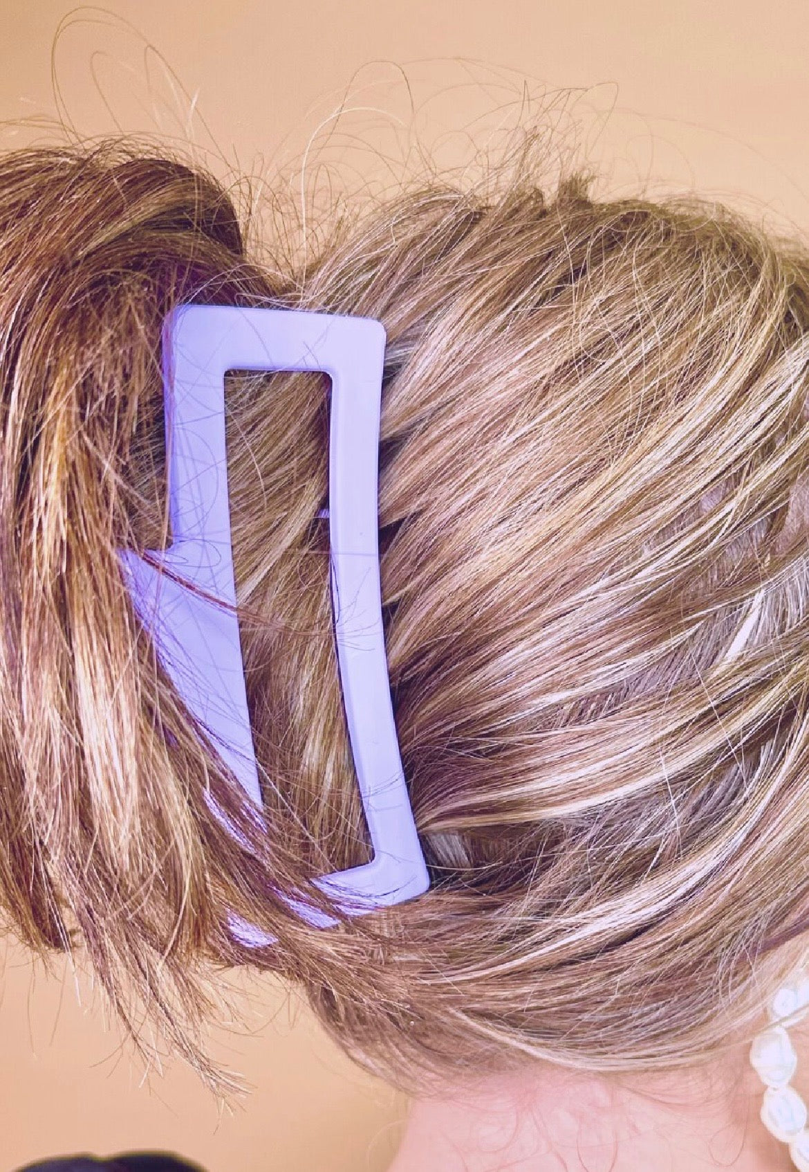 Close-up of a person's hair with a lavender hair clip.