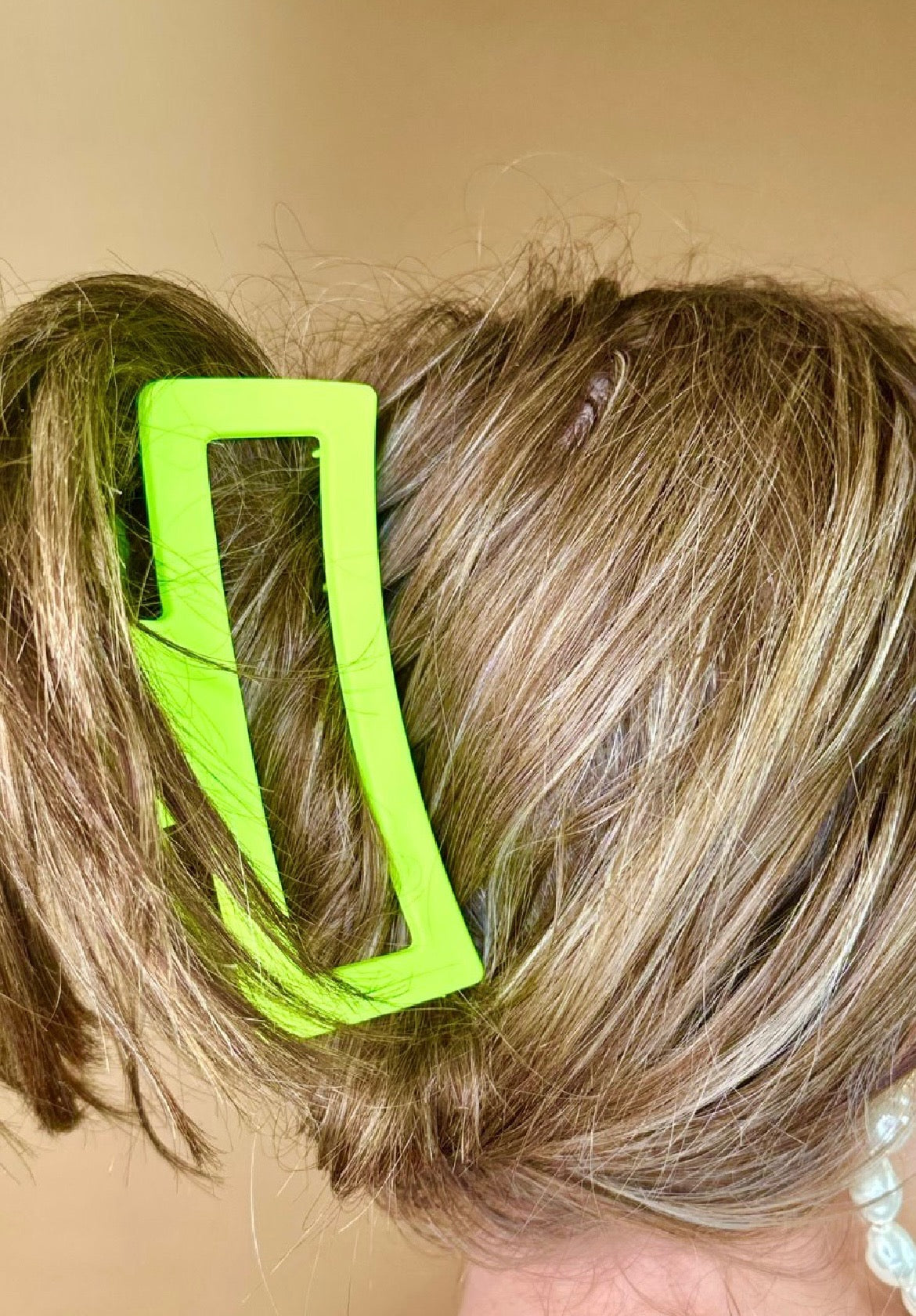 Close-up of a person's hair with a lime hair clip.