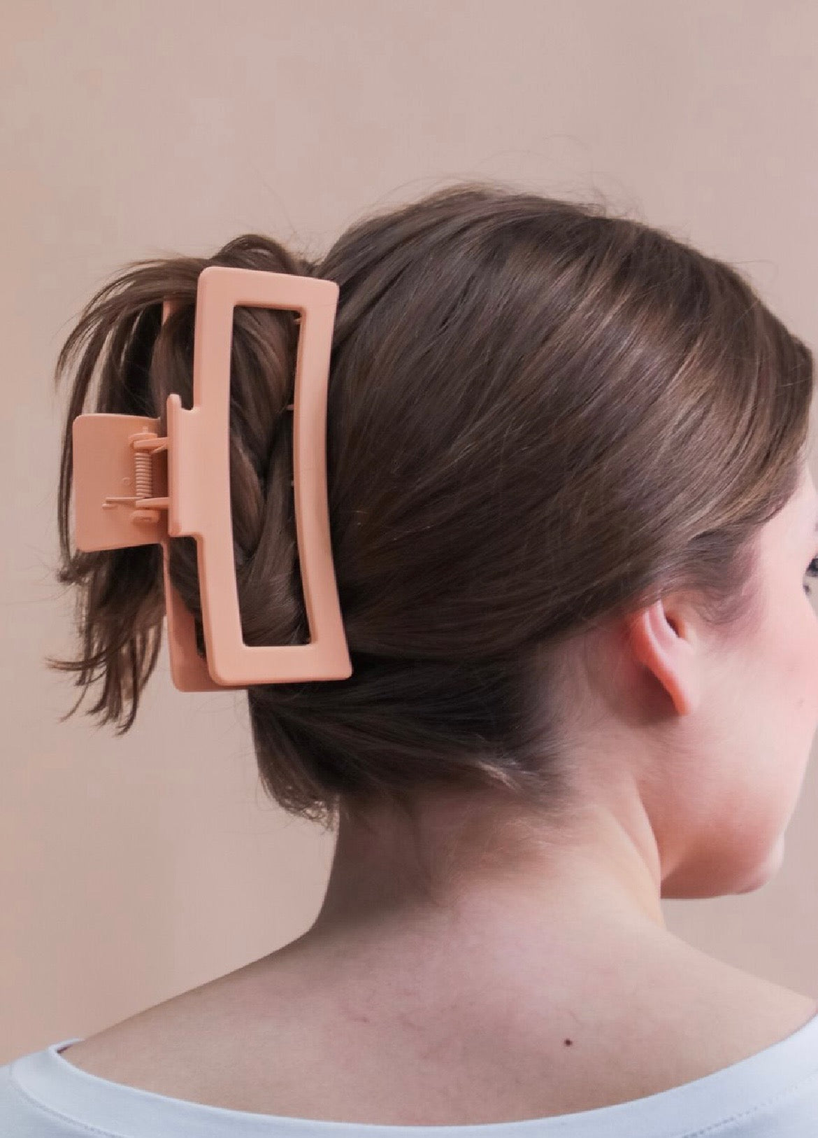 Close-up of a person's hair with a peach hair clip.