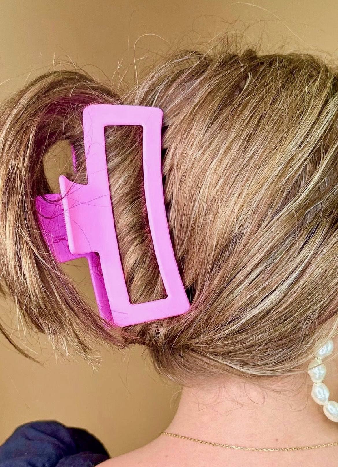 Close-up of a person's hair with a pink hair clip.