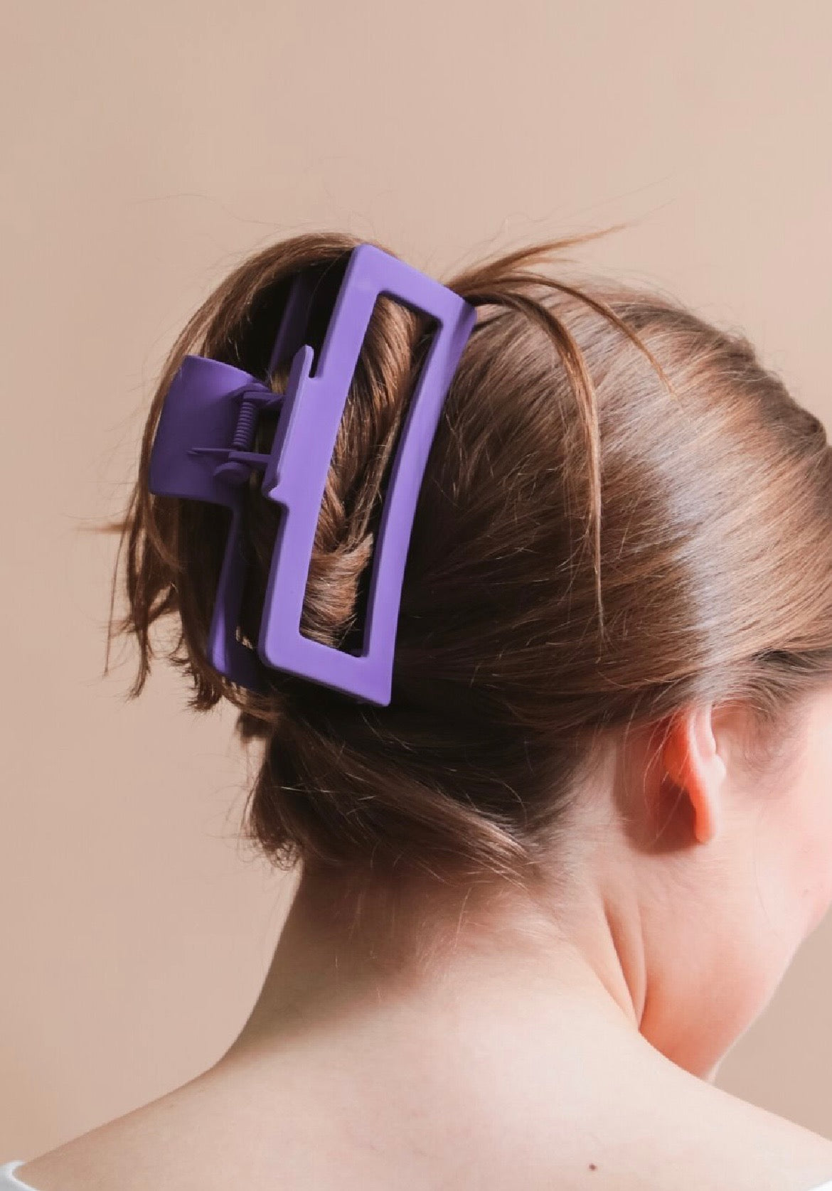 Close-up of a person's hair with a purple hair clip.