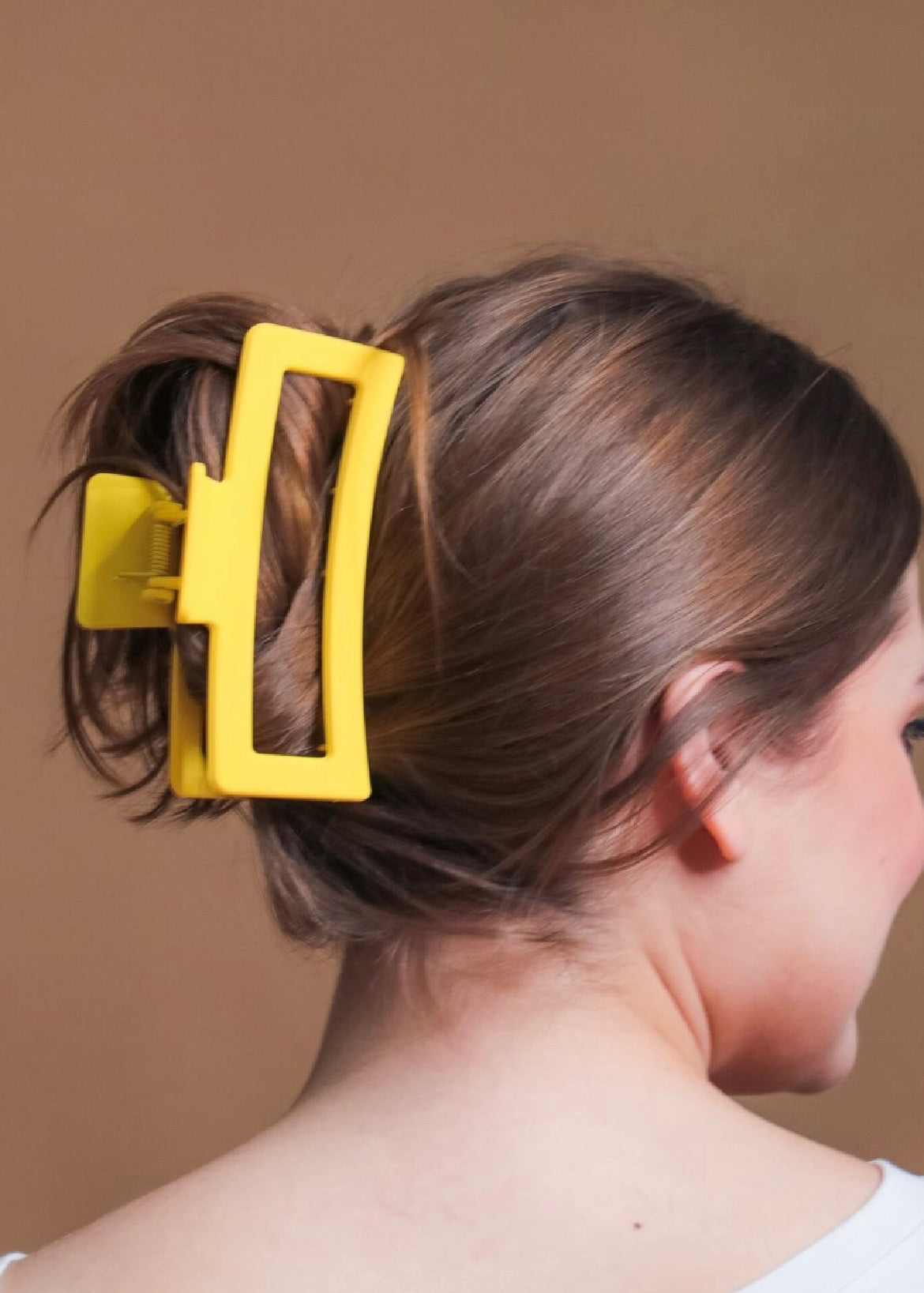 Close-up of a person's hair with a yellow hair clip.