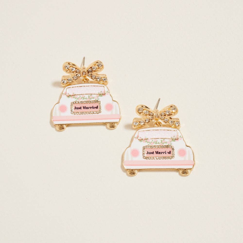 Pair of 'Just Married' wedding car earrings on a light beige background