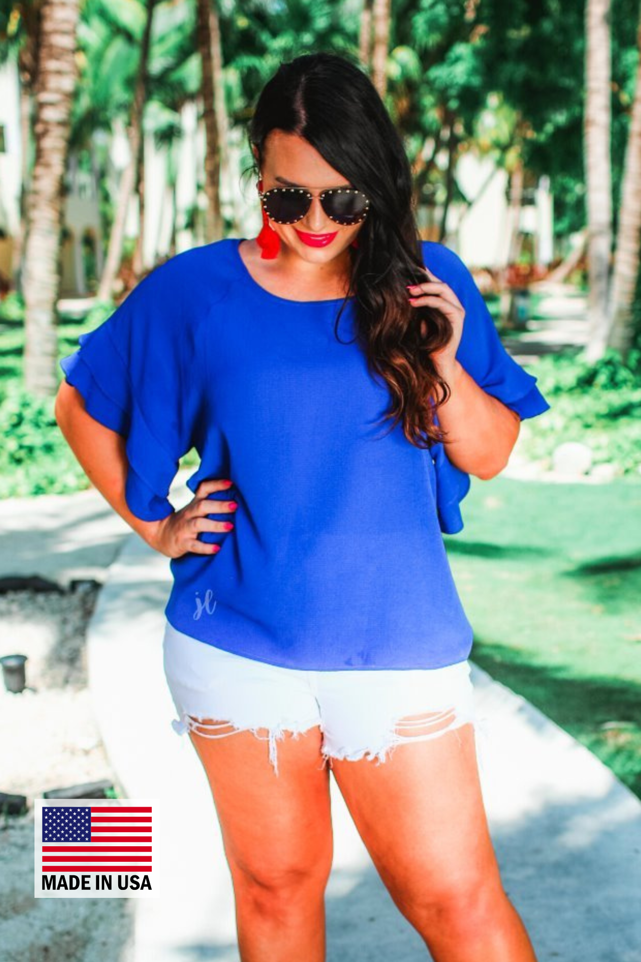 a blue true-to-size blouse crafted from lightweight textured fabric with a rounded neckline, tiered ruffle sleeves, and a relaxed drape, accented by a MADE IN USA watermark in the bottom left-hand corner