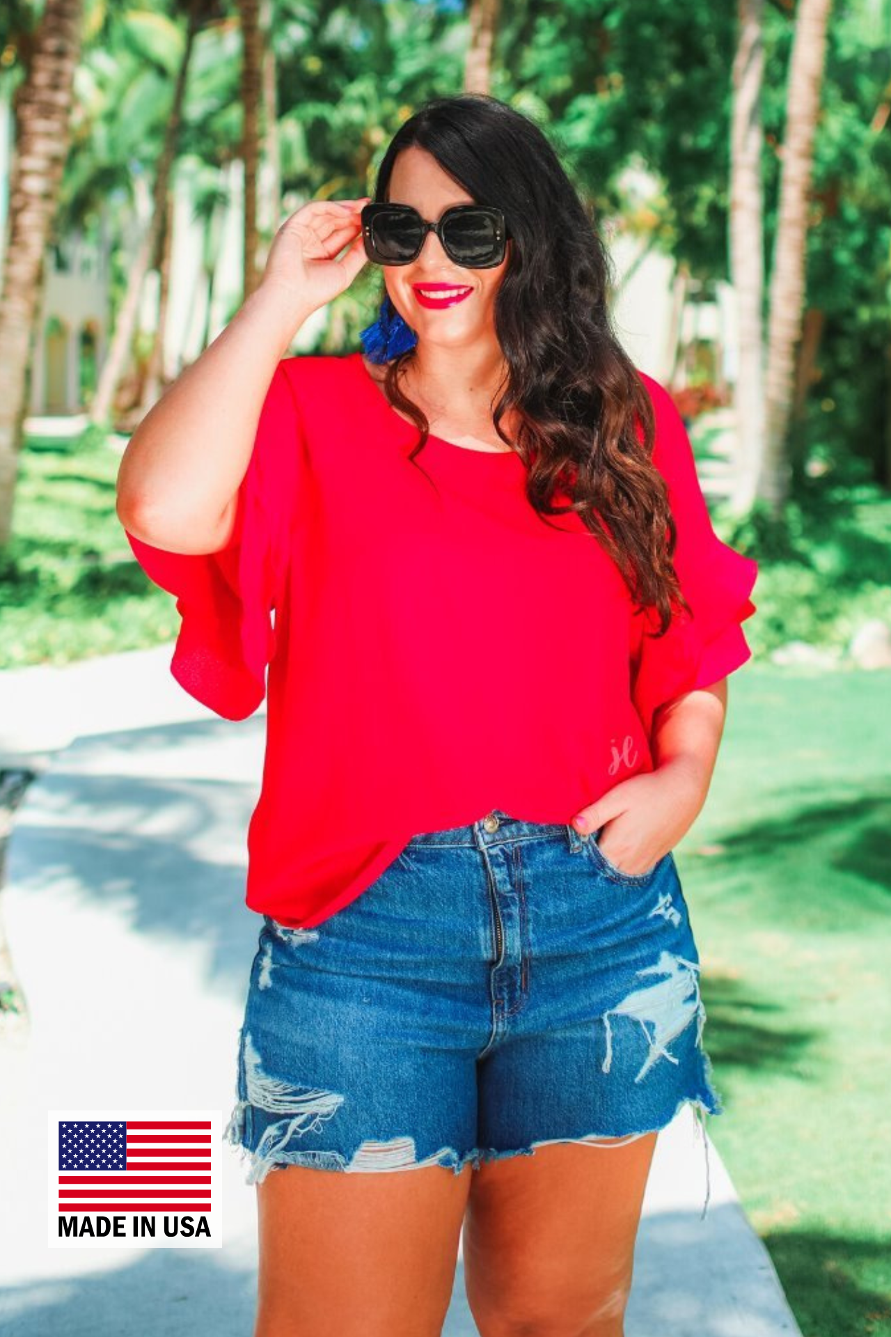 a red true-to-size blouse crafted from lightweight textured fabric with a rounded neckline, tiered ruffle sleeves, and a relaxed drape, accented by a MADE IN USA watermark in the bottom left-hand corner