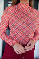 long-sleeve mesh top with a mock neckline and a lettuce hem on a plaid pattern (burgundy, brown, cream, and orange)
