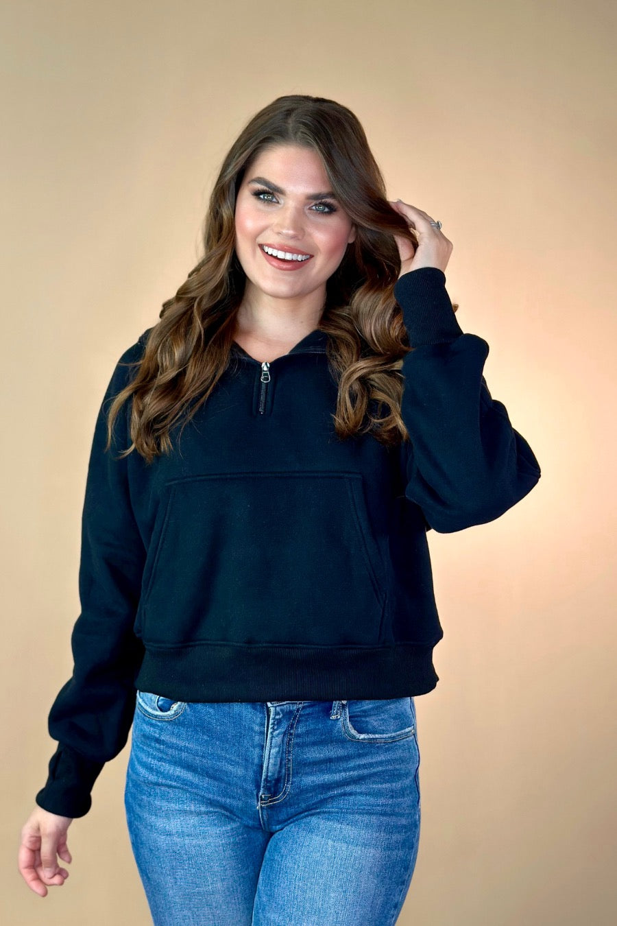 a cropped hooded quarter zip pullover with a relaxed fit, functional kangaroo pocket, and thumb holes in black