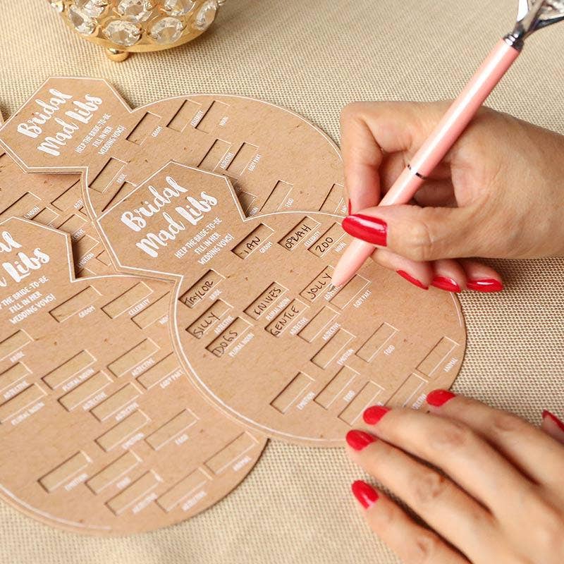 Person using a pink pen to write on cardboard templates with text and names.