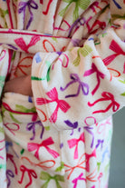 a long sleeve robe with a flattering wrap silhouette, an adjustable waist tie, a playful ruffle hem, and deep patch pockets on ultra plush fabric in Daylight Bow (Multi)