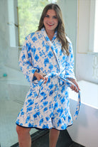 a long sleeve robe with a flattering wrap silhouette, an adjustable waist tie, a playful ruffle hem, and deep patch pockets on ultra plush fabric in Blue Blossom (Blue)