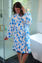 a long sleeve robe with a flattering wrap silhouette, an adjustable waist tie, a playful ruffle hem, and deep patch pockets on ultra plush fabric in Blue Blossom (Blue)