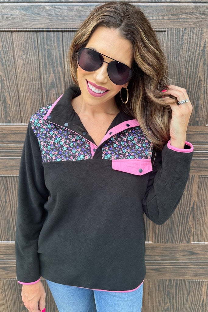 black fleece with floral print, pops of pink detailing, and snaps