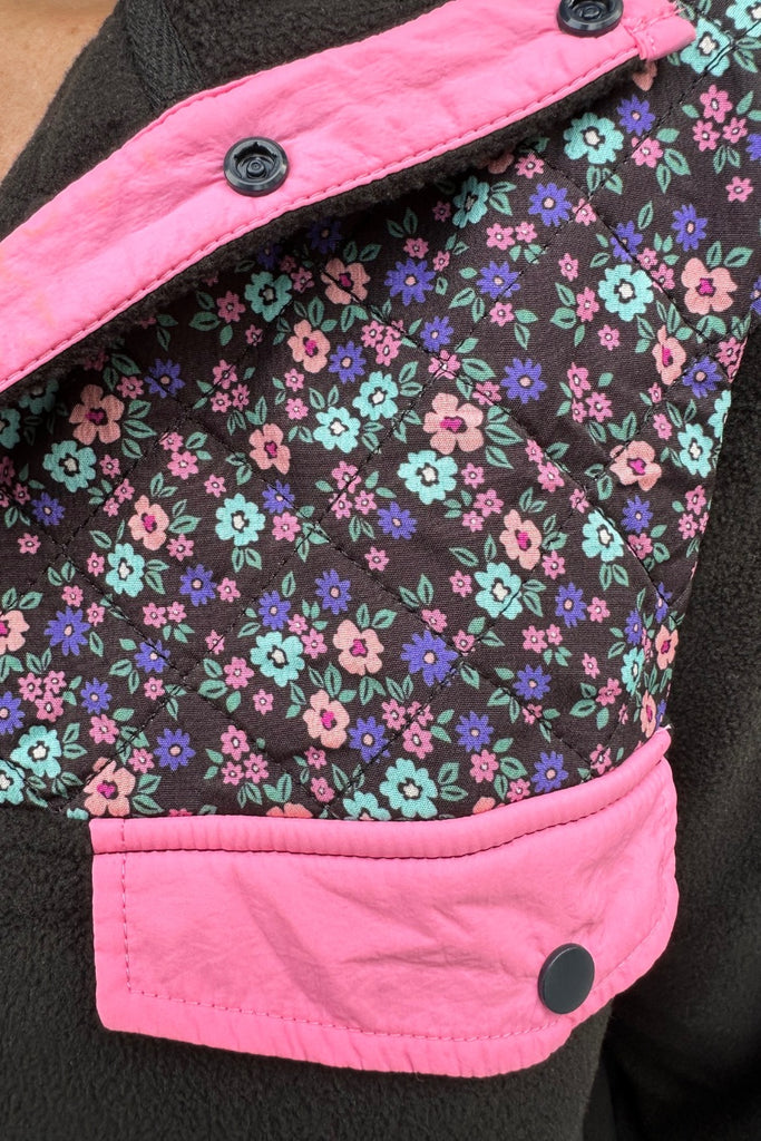 black fleece with floral print, pops of pink detailing, and snaps