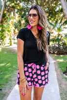  mid-rise, tie waist drawstring with gold bead accent, side pockets, & relaxed fit on a black with pink disco pattern fabric