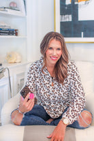 a long-sleeve pullover with a quarter zip, foldable collar, and a side split hem on a neutral leopard pattern fleece fabric