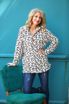a long-sleeve pullover with a quarter zip, foldable collar, and a side split hem on a neutral leopard pattern fleece fabric