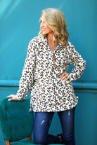 a long-sleeve pullover with a quarter zip, foldable collar, and a side split hem on a neutral leopard pattern fleece fabric