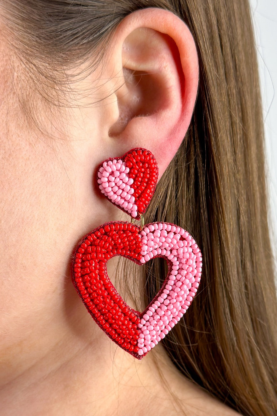 two-toned mirrored heart-shaped dangle earrings with a comfort back and a plastic disc stopper in gold