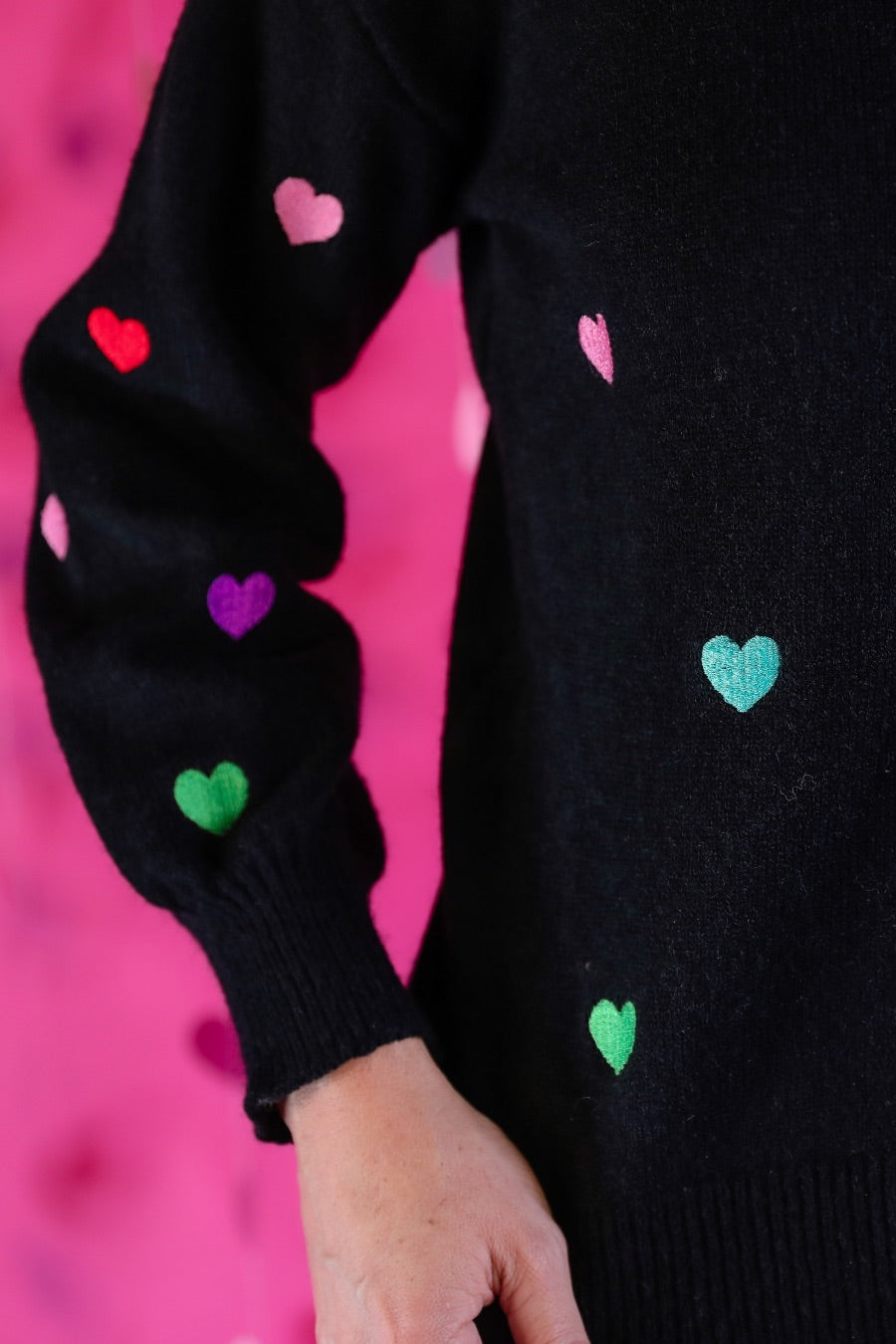 black long sleeve sweater adorned with colorful embroidered hearts