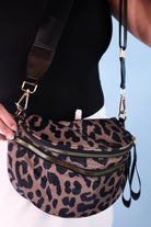 spacious bum bag with double front zippers, a back zipper, an interior zipper pocket, an adjustable strap, and gold hardware accents in lyra leopard
