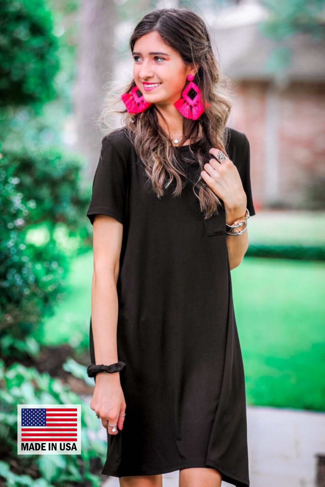 an ultra soft black T-shirt dress with an easy A-line silhouette, short sleeves, a round neckline, a chest pocket, and a straight hemline with MADE IN USA watermark in the bottom left hand corner