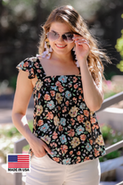 MADE IN USA a sleeveless tank with a squared neckline, ruffle tank sleeves, and a flowy body on a floral pattern and black base