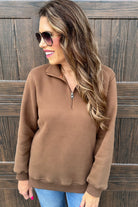 long-sleeve pullover made of cozy fabric with a quarter zip, cuffs, and a split waistband hem in brown