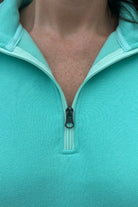 long-sleeve pullover made of cozy fabric with a quarter zip, cuffs, and a split waistband hem in turquoise