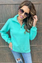 cozy fabric, a quarter zip, and a waistband hem in turquoise