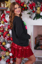 black long-sleeve sweatshirt with stitched chenille patches that spell out MERRY BRIGHT with an ampersand in between in alternating green, pink, and red on our new luxe material