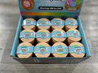 A retail display box filled with multiple small round mystery toy containers. The box is light blue with colorful graphics and text including 'What Color Will You Get?' and 'Mystery'.