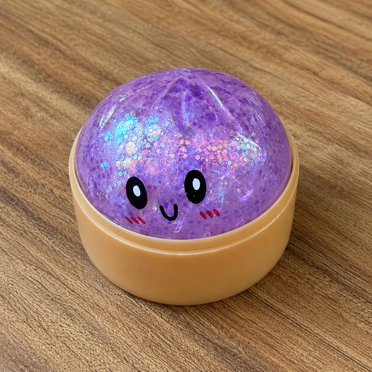 a purple mystery bead-filled mini dumpling squishy with assorted colors, iridescent shimmer, kawaii face, steamer-style container, and soft sensory texture