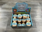 A retail display box labeled 'The Viral Mystery Dumpling' filled with multiple small round dumpling packages, photographed on a gray wood floor.