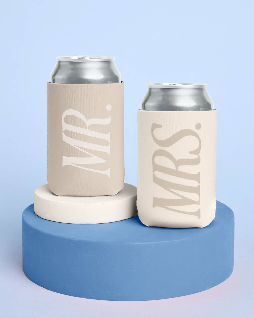 Two can coolers labeled 'MR.' and 'MRS.' on a blue platform with a light blue background.