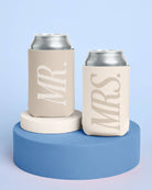 Two can coolers labeled 'MR.' and 'MRS.' on a blue platform with a light blue background.