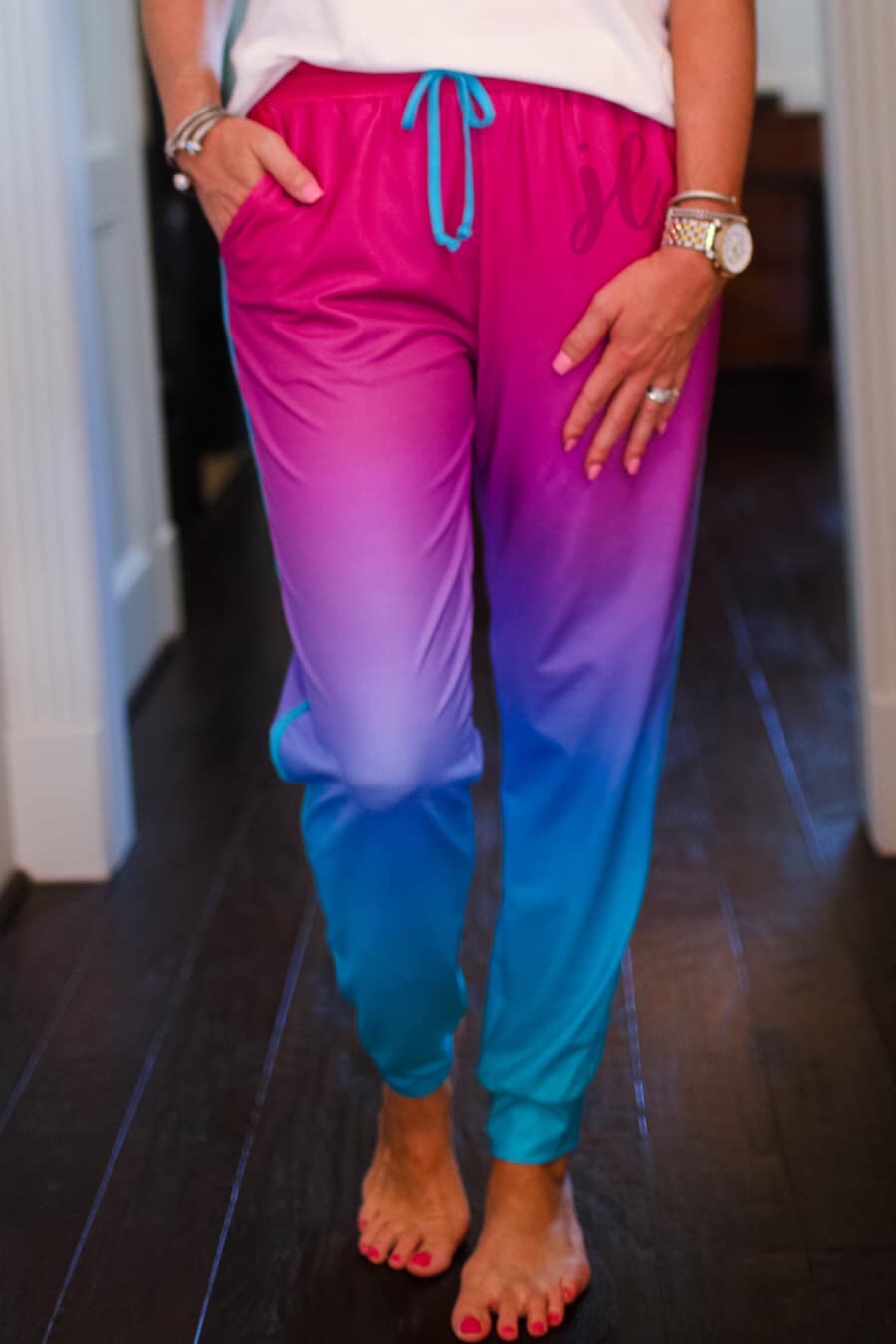 relaxed fit mid-rise joggers with side pockets and a tie waist drawstring, designed on a magenta to turquoise ombré print fabric with turquoise trim