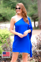 a royal blue one-shoulder mini dress with an asymmetrical neckline and a draping, billowy body creating a relaxed silhouette with a MADE IN USA watermark in bottom lefthand corner