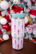 30-ounce striped pale pink insulated tumbler with a variety of whimsical multicolor pastel nutcrackers and peppermint swirls on white lace with a mint sturdy built-in handle, lid, and straw complete with silver hardware