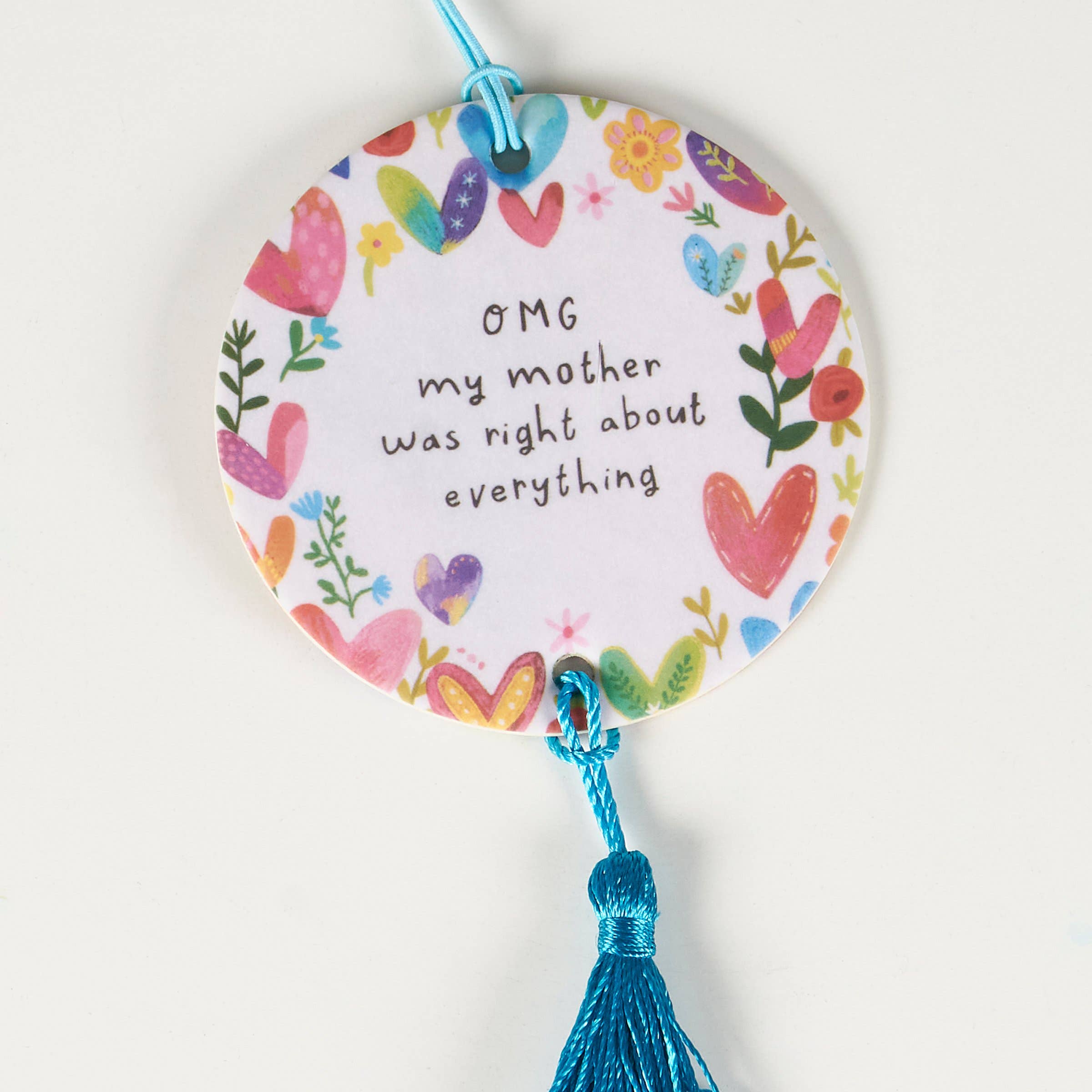Decorative round tag with colorful hearts and text, tied with a blue string on a white background