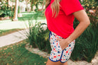 mid-rise relaxed fit activewear shorts with side pockets and a tie waist drawstring with gold bead accents, designed on a patriotic star pattern print fabric, white base, and navy trim