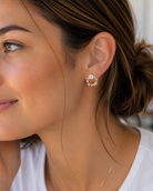gold-plated mini hoop post-stud earrings with a petite circular silhouette, butterfly cubic zirconia stones in soft pastel shades, crystal accents, a pearl detail, floral embellishments, and gold comfort backs