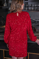 a red long balloon sleeve dress made of sparkly allover sequins, luxe velvet underlay, a keyhole accented upper back with button closure, a round neckline, and subtle elastic cuffs