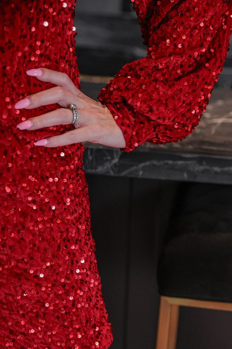 a red long balloon sleeve dress made of sparkly allover sequins, luxe velvet underlay, a keyhole accented upper back with button closure, a round neckline, and subtle elastic cuffs