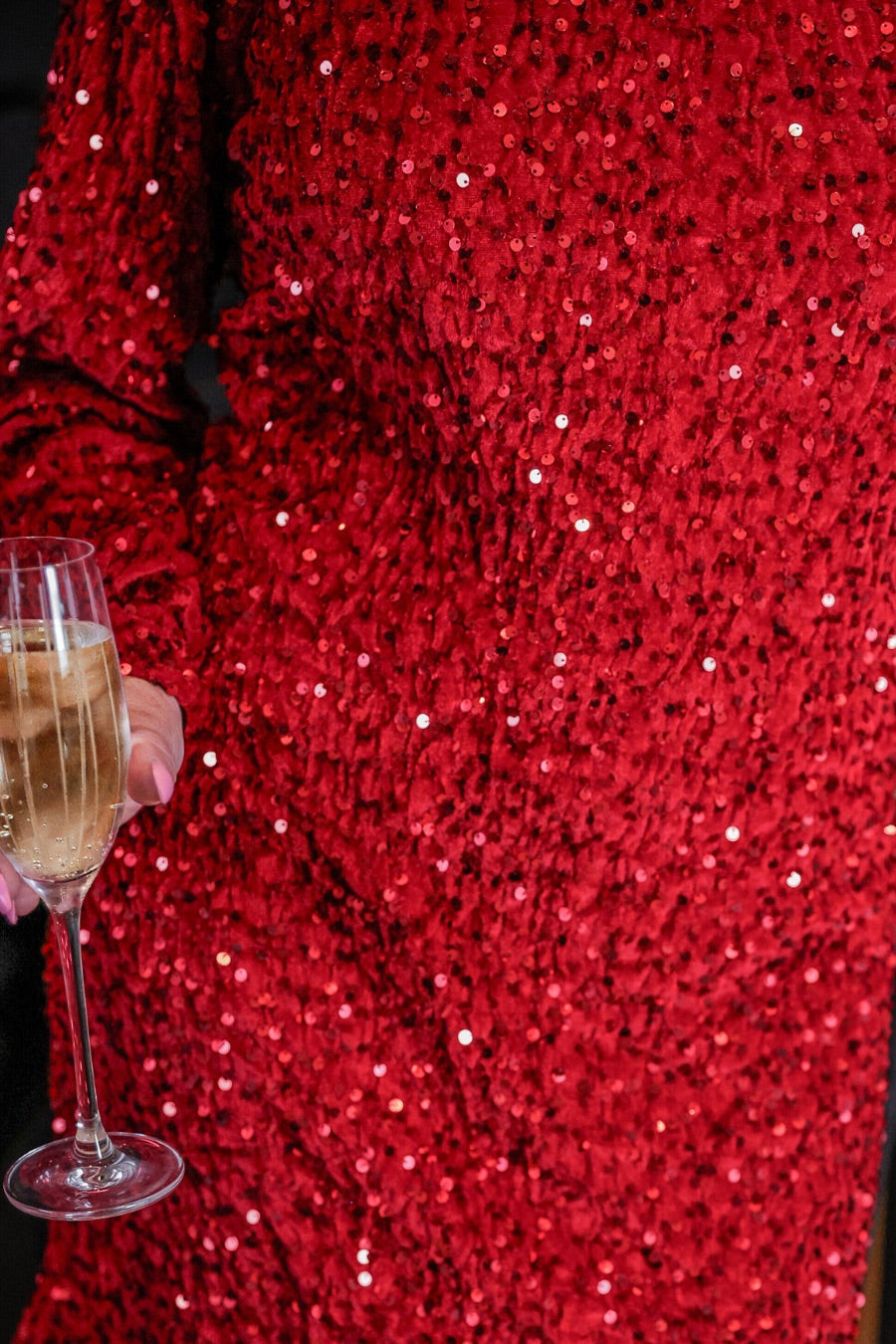 a red long balloon sleeve dress made of sparkly allover sequins, luxe velvet underlay, a keyhole accented upper back with button closure, a round neckline, and subtle elastic cuffs