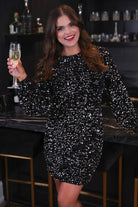a black long balloon sleeve dress made of sparkly allover sequins, luxe velvet underlay, a keyhole accented upper back with button closure, a round neckline, and subtle elastic cuffs