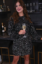 a black long balloon sleeve dress made of sparkly allover sequins, luxe velvet underlay, a keyhole accented upper back with button closure, a round neckline, and subtle elastic cuffs