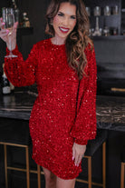 a red long balloon sleeve dress made of sparkly allover sequins, luxe velvet underlay, a keyhole accented upper back with button closure, a round neckline, and subtle elastic cuffs