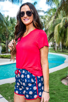 mid-rise relaxed fit activewear shorts with side pockets and a tie waist drawstring with gold bead accents, designed on a baseball pattern print fabric, royal blue base, and red trim